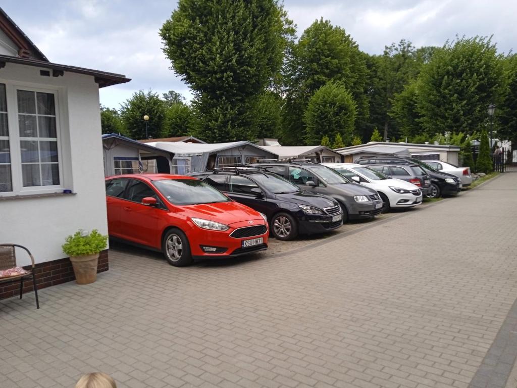 una fila de autos estacionados en un estacionamiento en Domki letniskowe Przyczepy kempingowe Zacisze Mielno, en Mielno