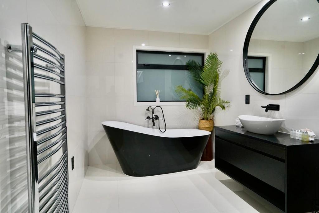 a bathroom with a black tub and a sink at A Dreamed Home Away From Home in Rotorua