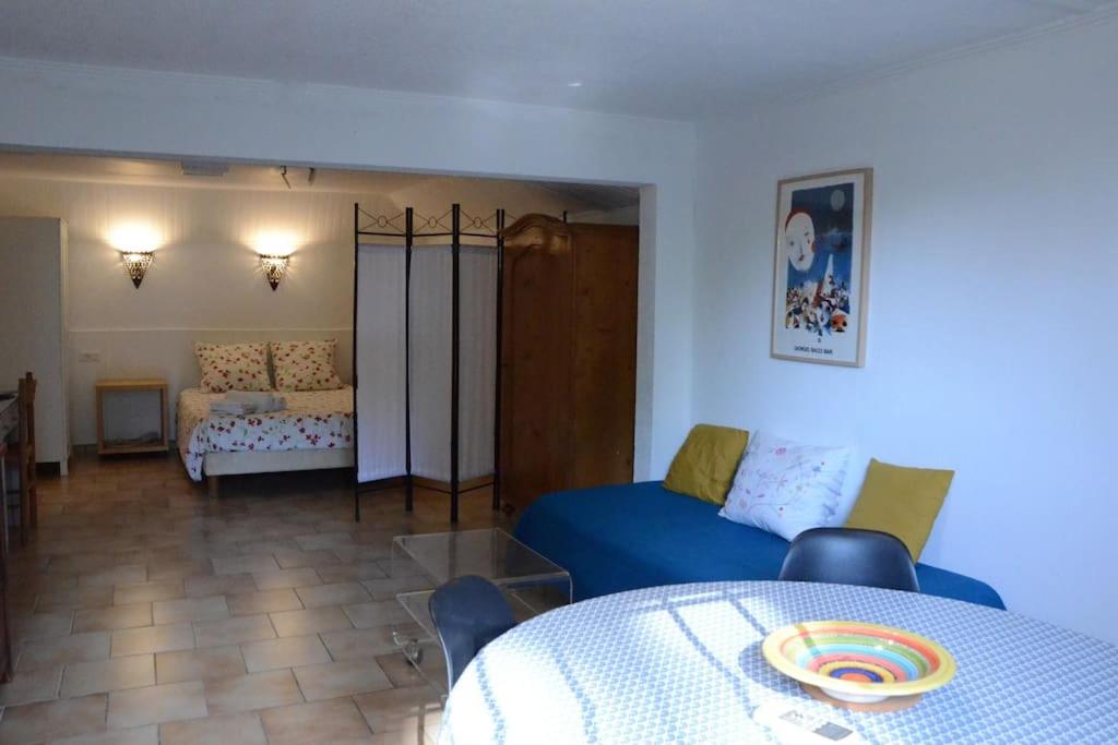 un salon avec un canapé bleu et une table dans l'établissement Studio 35m2 climatisé, 10mn des calanques, à La Ciotat