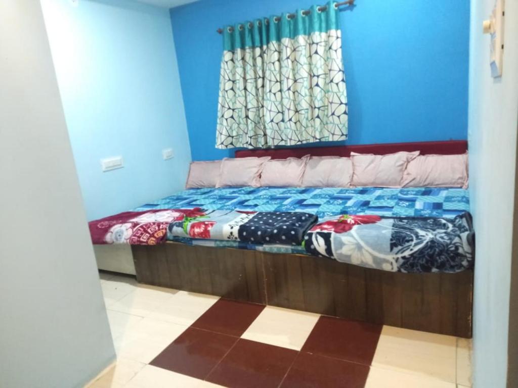 a bedroom with a bed in a room with blue walls at Bhagwati Guest House Ujjain in Ujjain