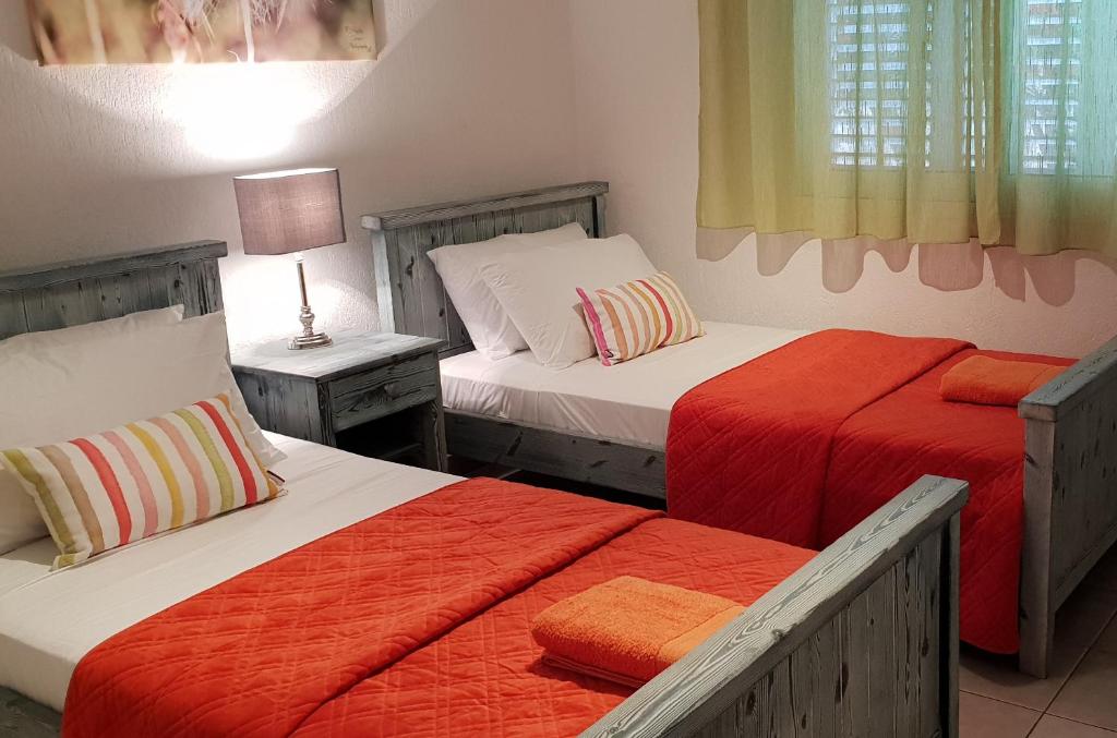 een slaapkamer met 2 bedden en 2 tafels met lampen bij Beach Shack in Klorakas