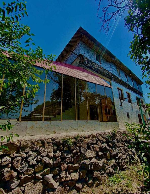a building with glass windows on top of a stone wall at Hotelvvv888 in Yerevan