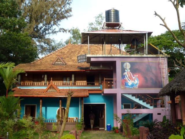 a house with a large advertisement on the side of it at Southcanal Holidays in Alleppey