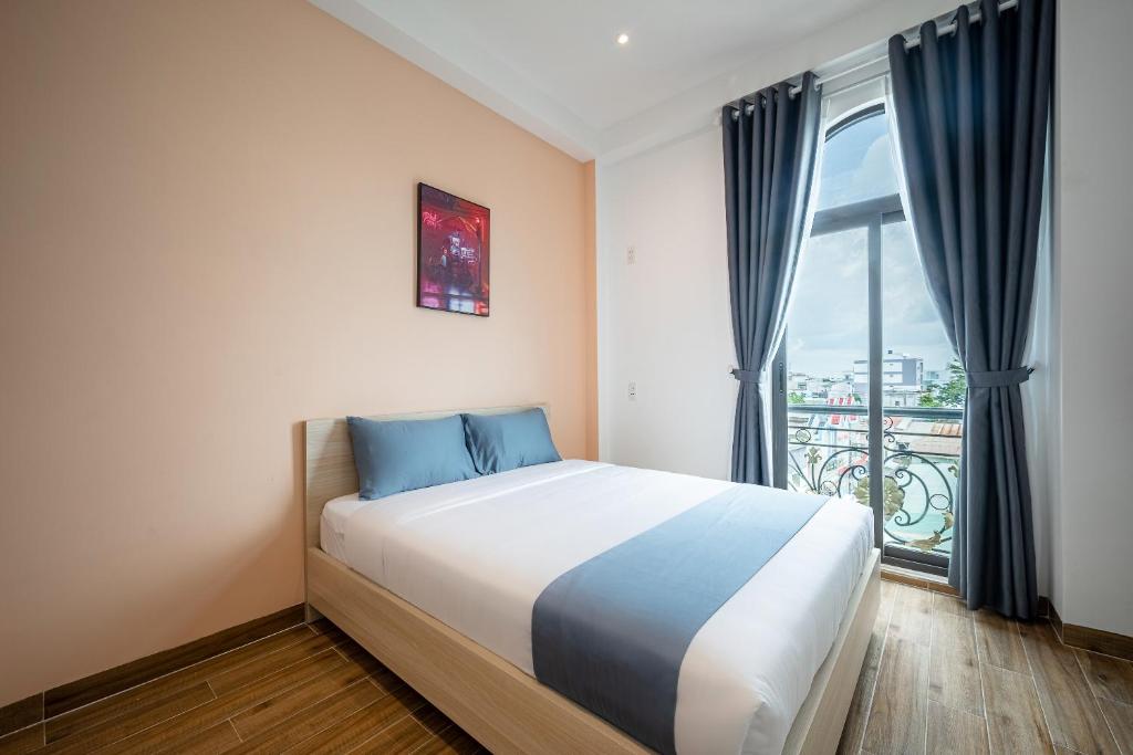 a bedroom with a large bed and a window at Cozrum Homes - Cozytel Residence in Ho Chi Minh City