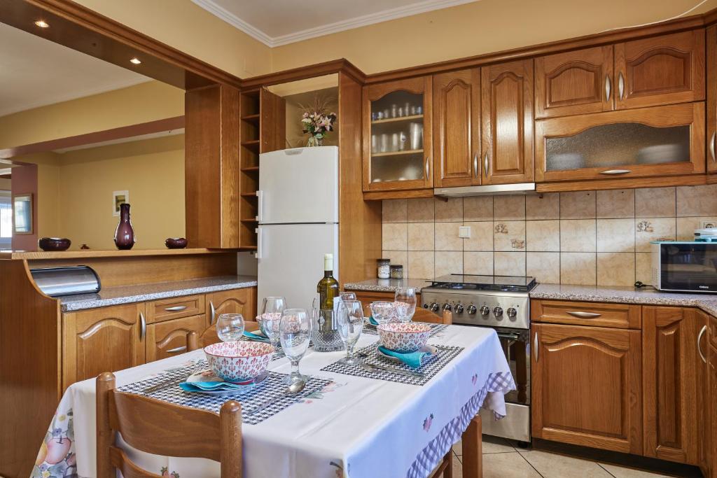 a kitchen with a table with wine glasses on it at Villa Roxa Montuoso in Agios Leon