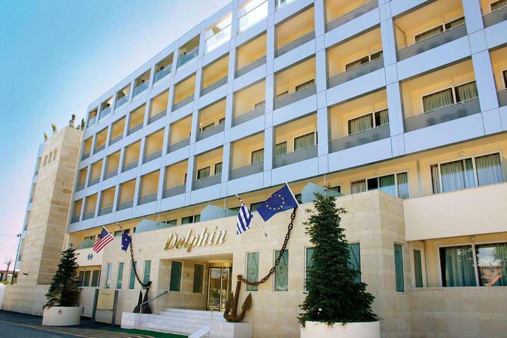 a building with american flags in front of it at Dolphin Resort & Conference in Kalamos