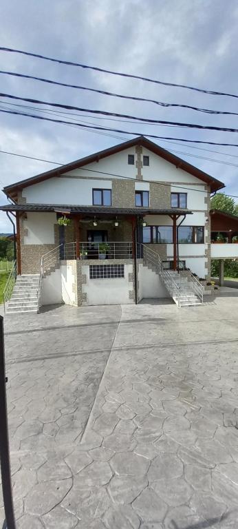 una casa con porche y escaleras delante en Pensiune Restaurant Alex, en Copalnic