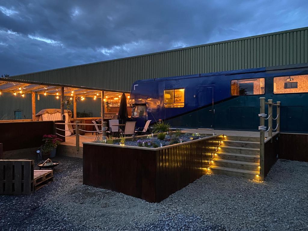a blue building with a table and chairs on a patio at Horse Truck Tiny Home in Swords