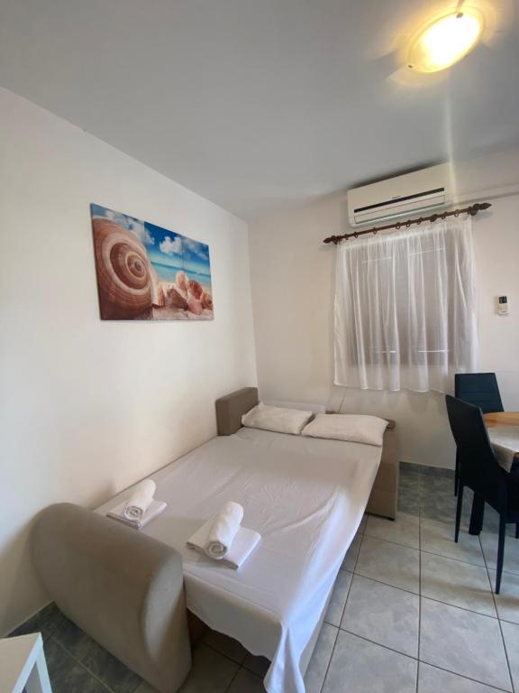 een kleine kamer met een bed en een tafel bij Novalja Beach Apartment in Novalja