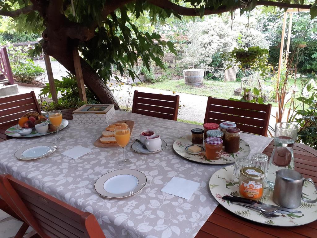 stół z talerzami jedzenia i szklanki soku pomarańczowego w obiekcie Au Bosquet, chambre et salle de bains avec petit déjeuner à 600 m du centre dans un cadre calme et verdoyant w mieście Salies-de-Béarn