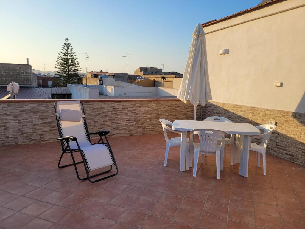 une terrasse avec une table, des chaises et un parasol dans l'établissement ANNABELL'S, à Cassibile