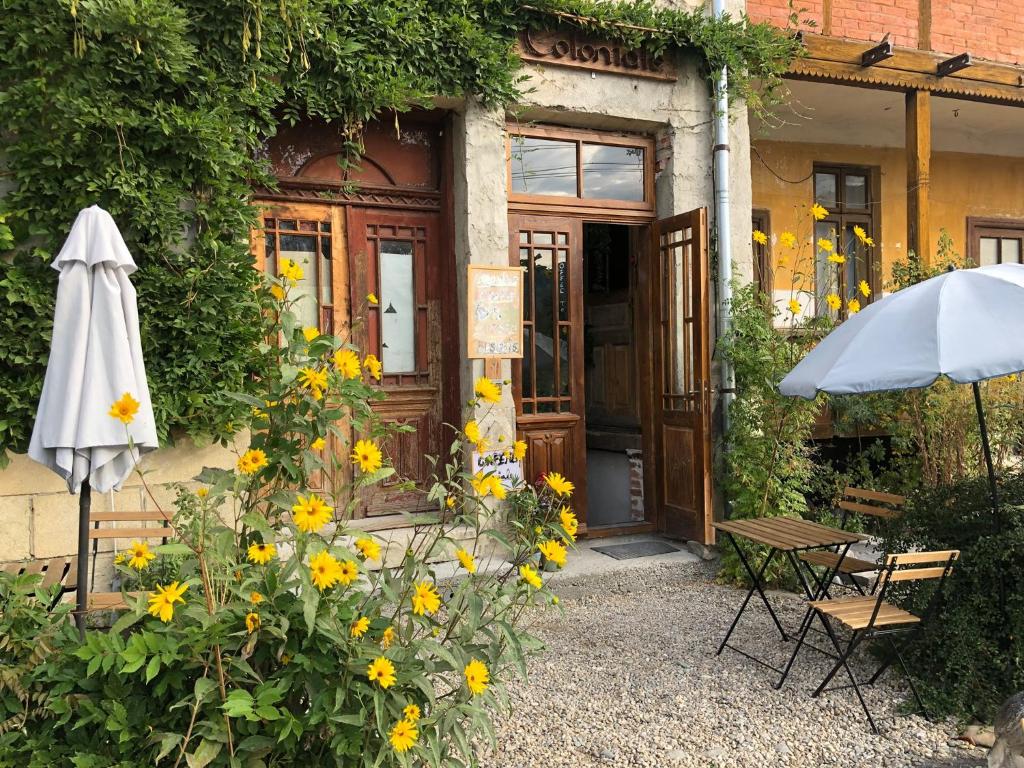 una casa con un paraguas y flores delante de ella en COLONIALE, en Cîmpulung