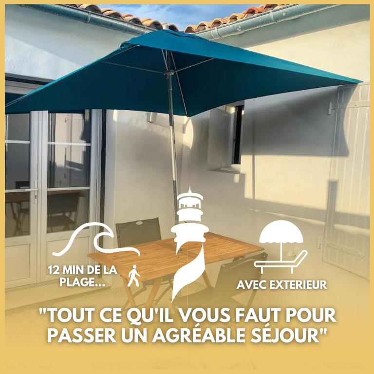 un parapluie bleu suspendu au-dessus d'une table avec un ordinateur portable dans l'établissement Phare de Chauveau - Maison de Charme à Sainte Marie, à Sainte-Marie de Ré
