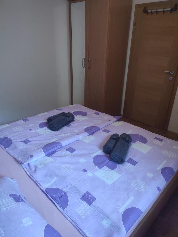a bed with two pairs of shoes on it at Počitniško stanovanje Aurora in Bovec