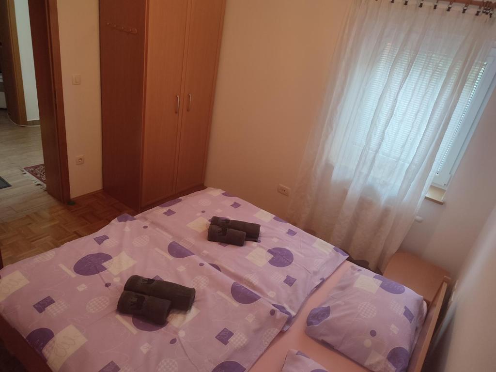 Piccola camera con letto e cuscino viola. di Počitniško stanovanje Aurora a Bovec