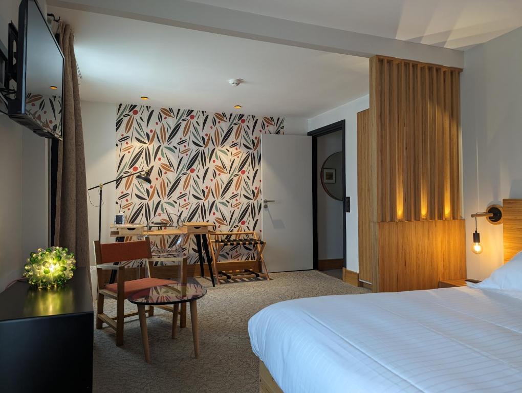 une chambre d'hôtel avec un lit, une table et des chaises dans l'établissement La Pension du Moulin, à Pont-Aven