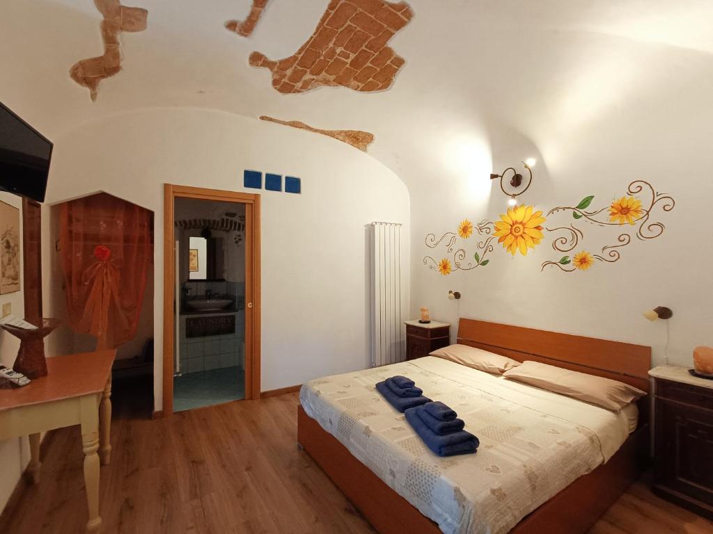 B&B Il Girasole في فينالي ليغوري: غرفة نوم عليها سرير وفوط زرقاء