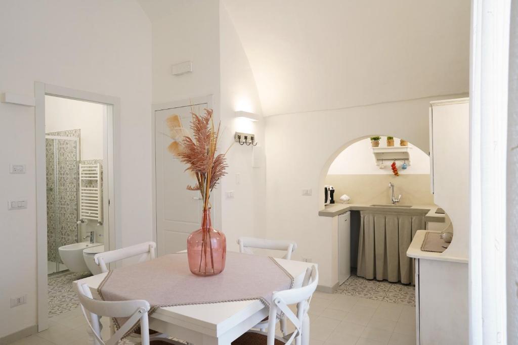 - une salle à manger avec une table et un vase dans l'établissement Le Cementine - Apulian Rooms, à Fasano