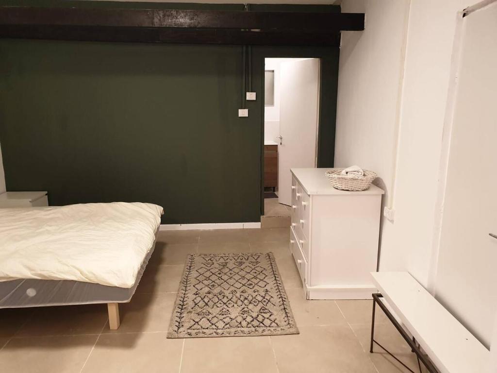a bedroom with a bed and a green wall at סטודיו איתמר in Tel Aviv