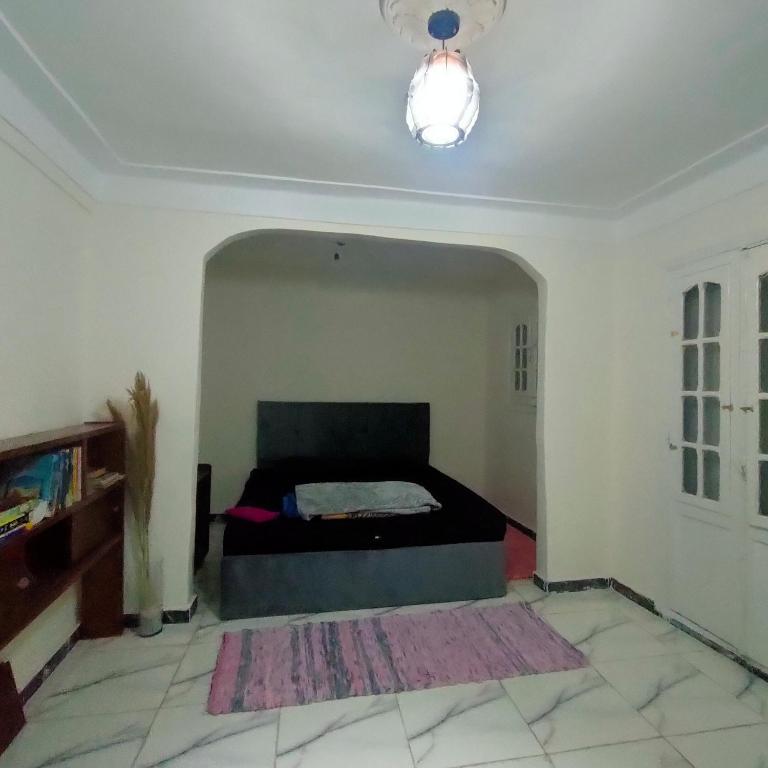 een slaapkamer met een bed in het midden van een kamer bij Egyptian Hostel in Alexandrië