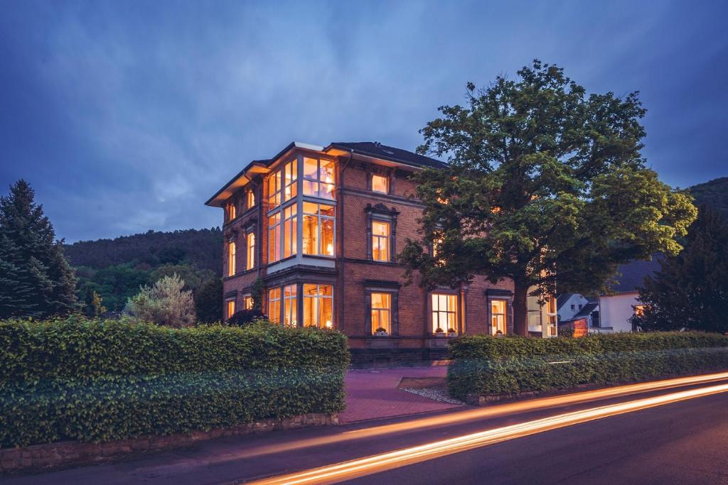 ein großes Haus mit nachts eingeschaltetem Licht in der Unterkunft Hotel Villa Sanct Peter in Bad Neuenahr-Ahrweiler