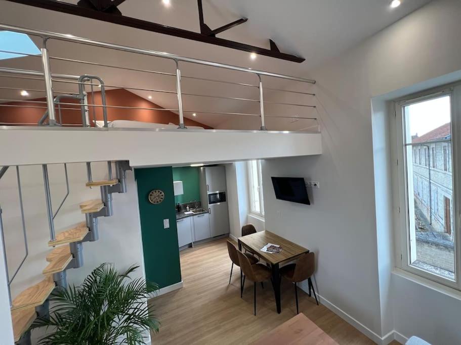 Appartamento loft con scala, tavolo e sedie. di Duplex type Loft centre ville * clim * WIFI * Haut de gamme * ad Angoulême