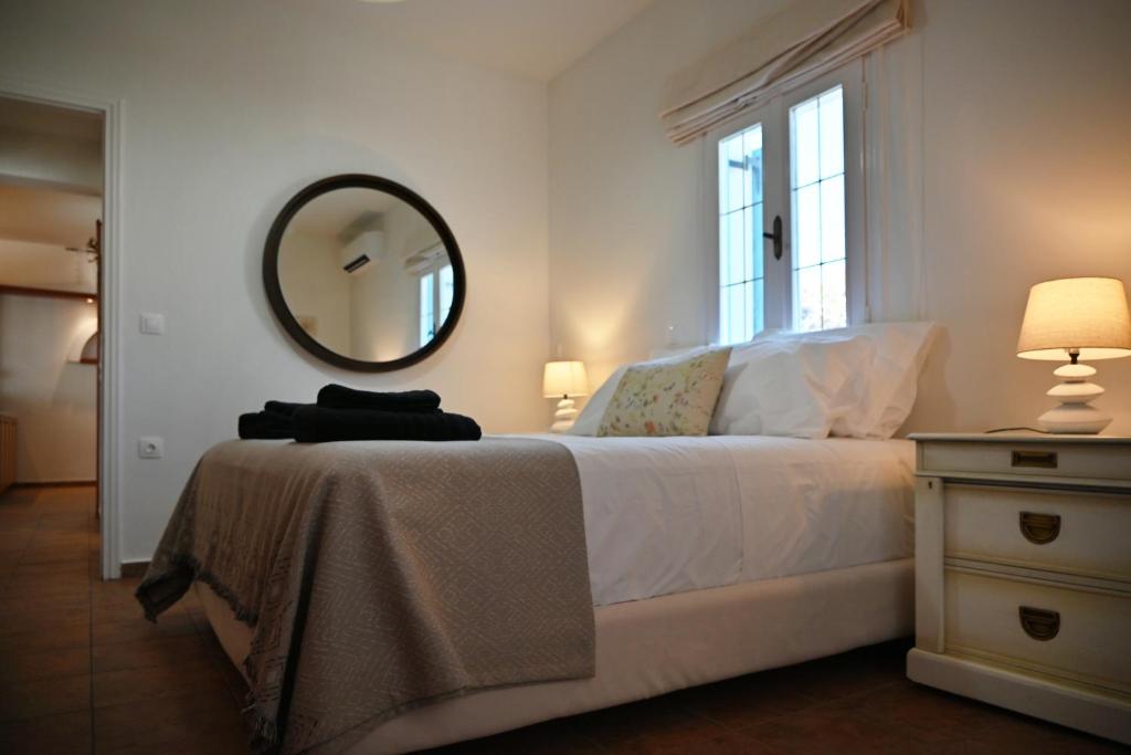 a bedroom with a bed with a mirror on the wall at GTK Santorini Perivolos Beach House in Perivolos