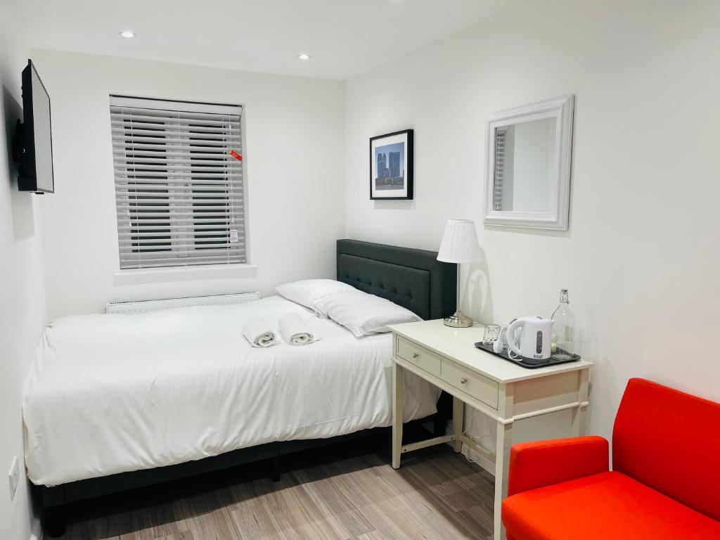 a bedroom with a bed and a red chair at Riverside Premium Double Room E14 in London
