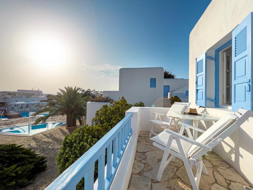 a balcony of a house with a table and chairs at Chora Resort Hotel & Spa in Chora Folegandros
