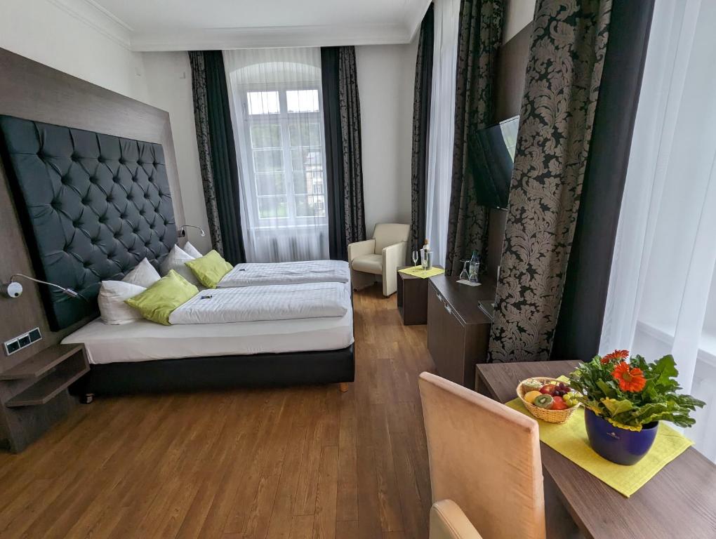 um quarto de hotel com uma cama e uma mesa e uma sala de jantar em Badhotel Bad Brückenau em Staatsbad Brückenau
