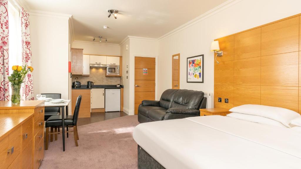 a hotel room with a bed and a kitchen at Teddington Lodge in Teddington