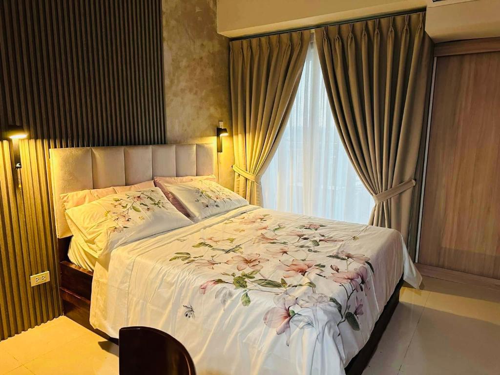 a bedroom with a large bed with flowers on it at Inspiria Abreeza Davao in Davao City
