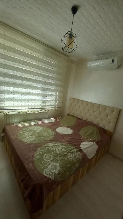 een slaapkamer met een groot bed in een kamer met een raam bij Çekirge Apart 5 in Çekirge