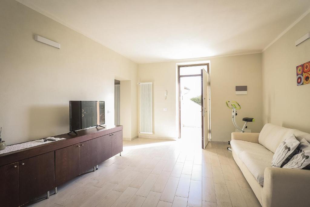 a living room with a couch and a tv at Appartamento nuovissimo con parcheggio gratuito in Massa