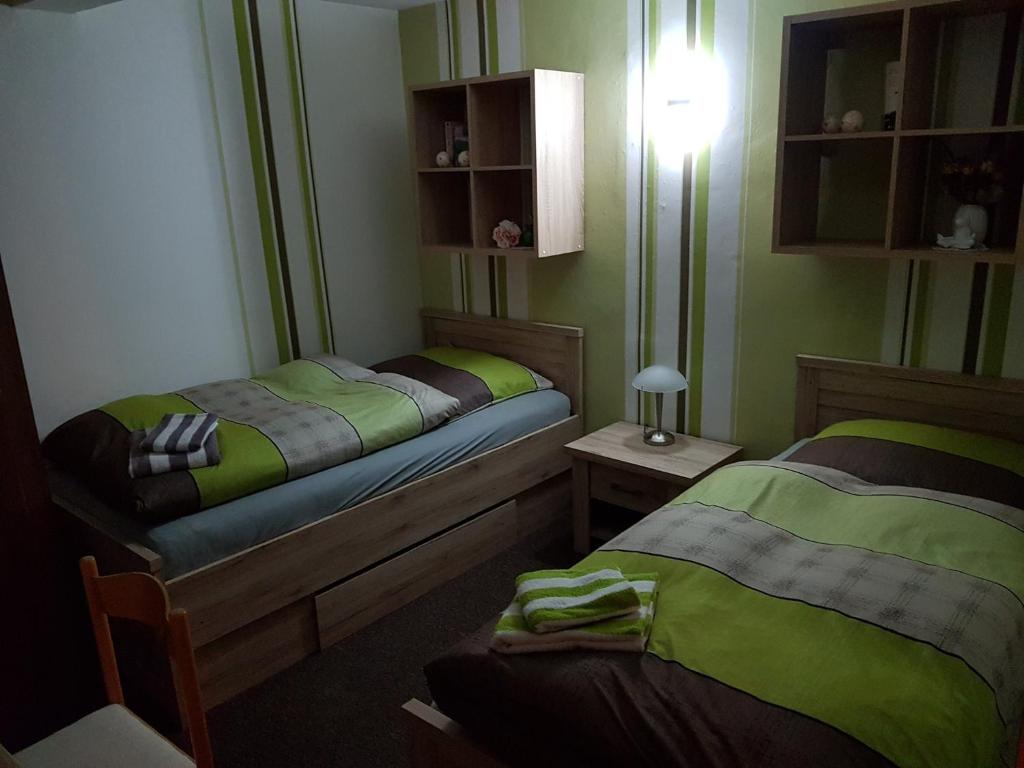 sypialnia z 2 łóżkami i lampką na stole w obiekcie Ferienwohnung Froeschlein 3 w mieście Ilmenau