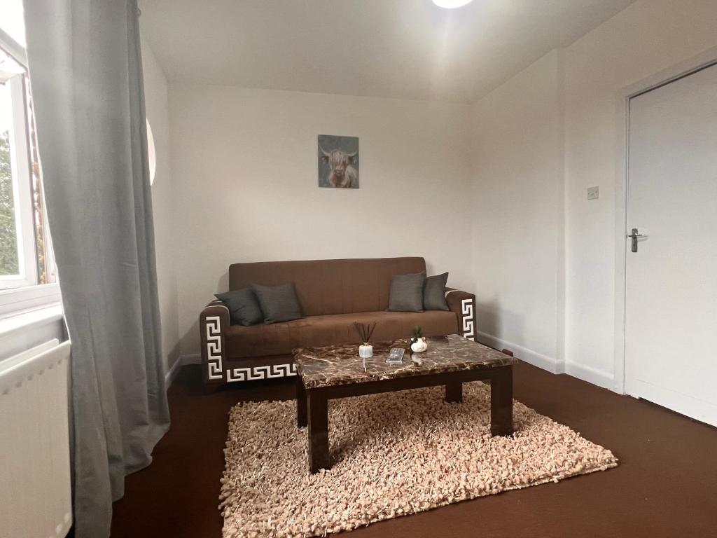 a living room with a couch and a coffee table at Neasden, Dollis Hill London Apartment in London