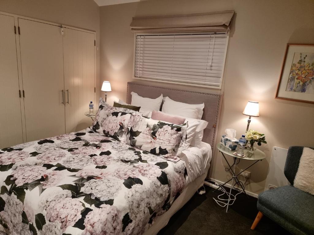 um quarto com uma cama preta e branca com flores em Haven Sanctuary Suite with Private Entrance em Queenstown