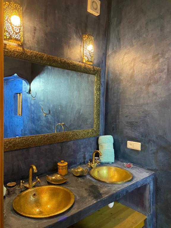 een badkamer met 2 wastafels en een spiegel bij DAR SEFFAH au cœur de la Médina in Fès