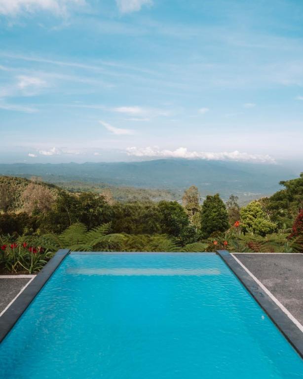 a swimming pool with a view of the mountains at Munduk Menir Villas in Munduk