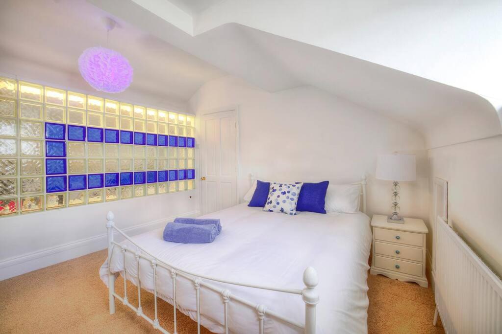 ein Schlafzimmer mit einem weißen Bett und einem Fenster in der Unterkunft Seaside spacious 4 BR Nr Town centre and Open Golf in West Kirby