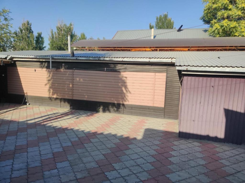 a building with two garage doors on the side of it at Уют in Zharkent