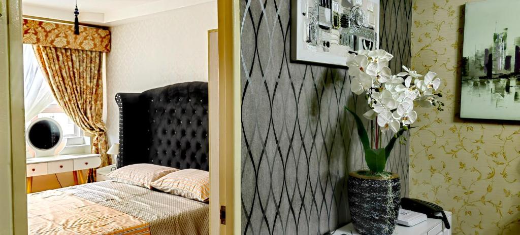 ダバオシティにあるCasa Felicitas 2のベッドルーム1室(ベッド1台付)、白い花の花瓶1枚