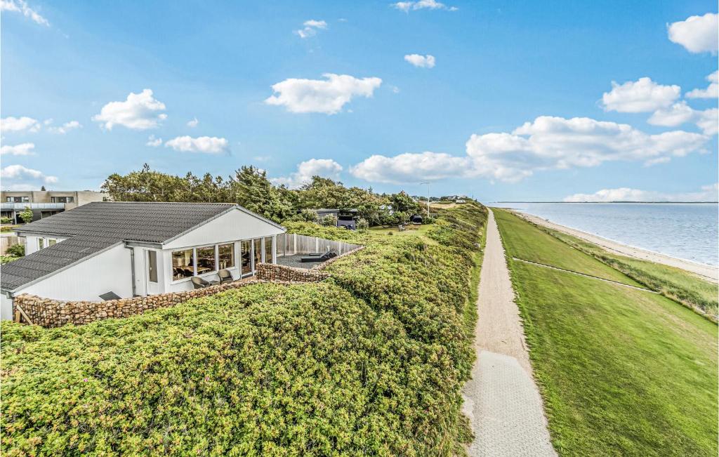 une maison à côté de l'eau avec une haie dans l'établissement Stunning Home In Esbjerg V With Wifi, à Esbjerg