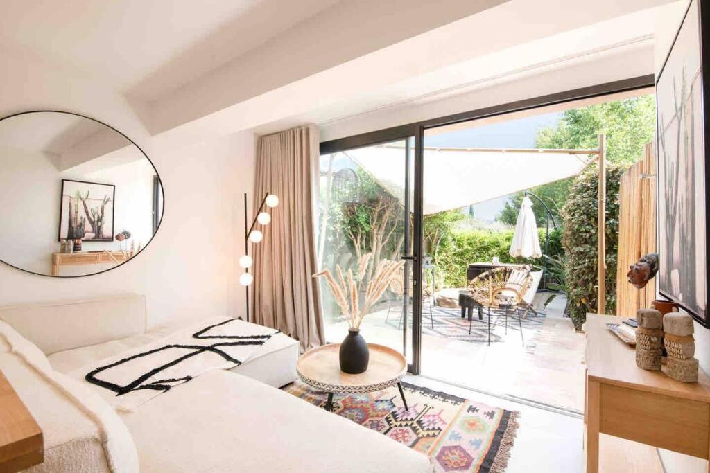 sala de estar con sofá y ventana grande en Suite de luxe 2 pièces golfe de Saint Tropez, en Sainte-Maxime