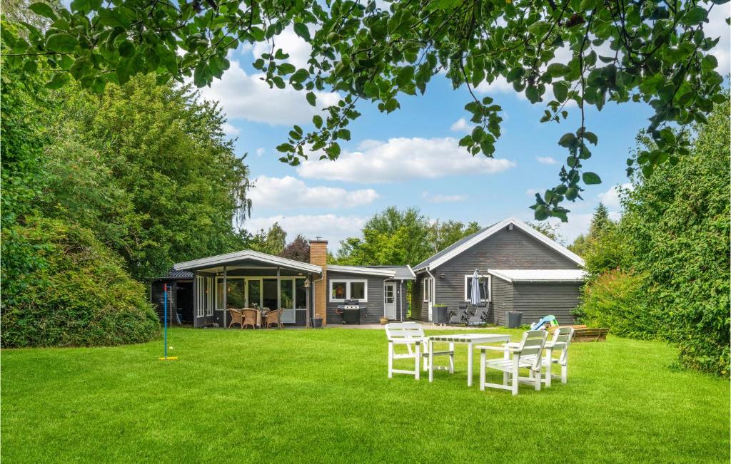a yard with a table and chairs in front of a house at Amazing Home In Jgerspris With Wifi And 2 Bedrooms in Jægerspris