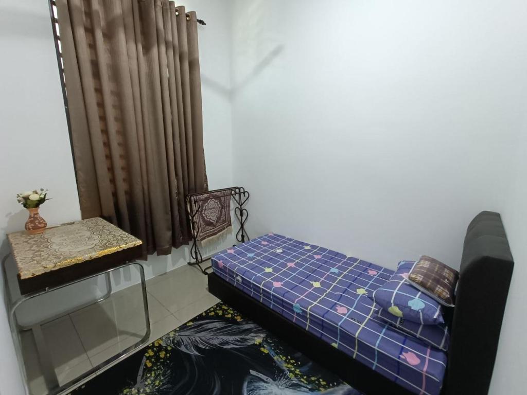 a small room with a bed and a window at Mira Homestay Gurun - Pendang in Pendang