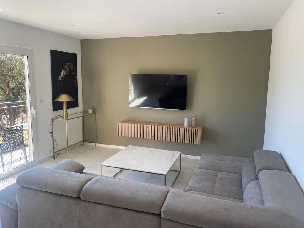 un salon avec un canapé et une télévision dans l'établissement Appartement T3 porto vecchio, à Porto-Vecchio