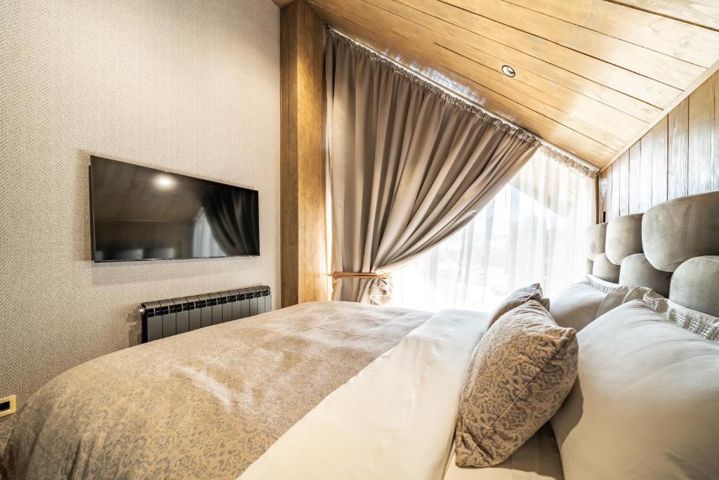 a bedroom with a large bed and a window at MONTE PINE CHALETS in Žabljak