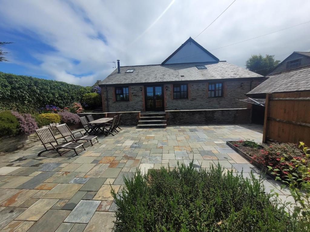a patio with two chairs and a house at Long Linhay in Woolacombe