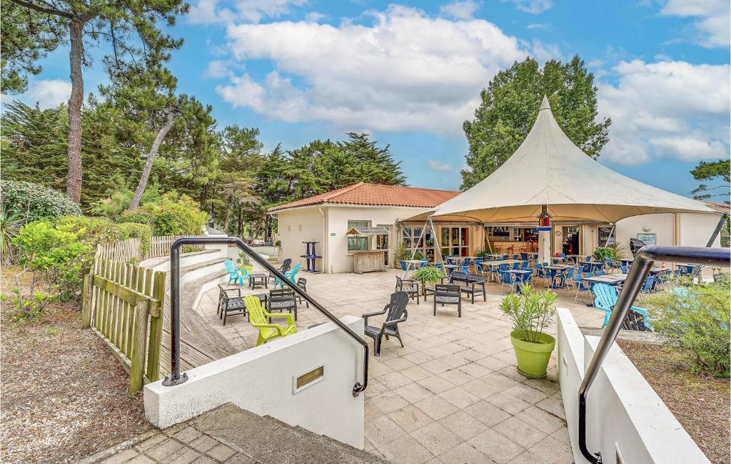 a patio with a tent and tables and chairs at 2 Bedroom Beautiful Home In La Faute-sur-mer in La Faute-sur-Mer